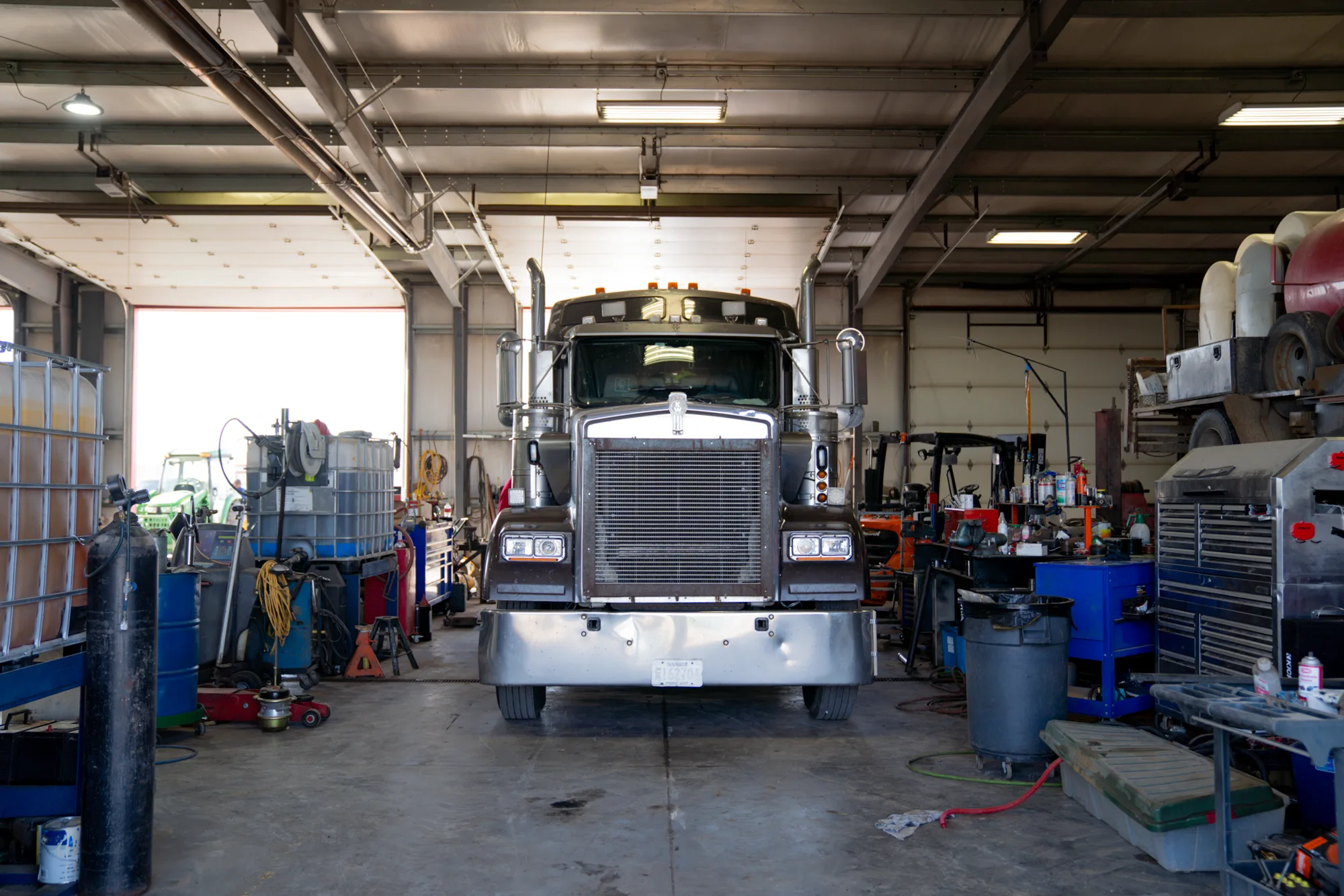 A J and J Services LLC truck parked inside the maintenance shop bay