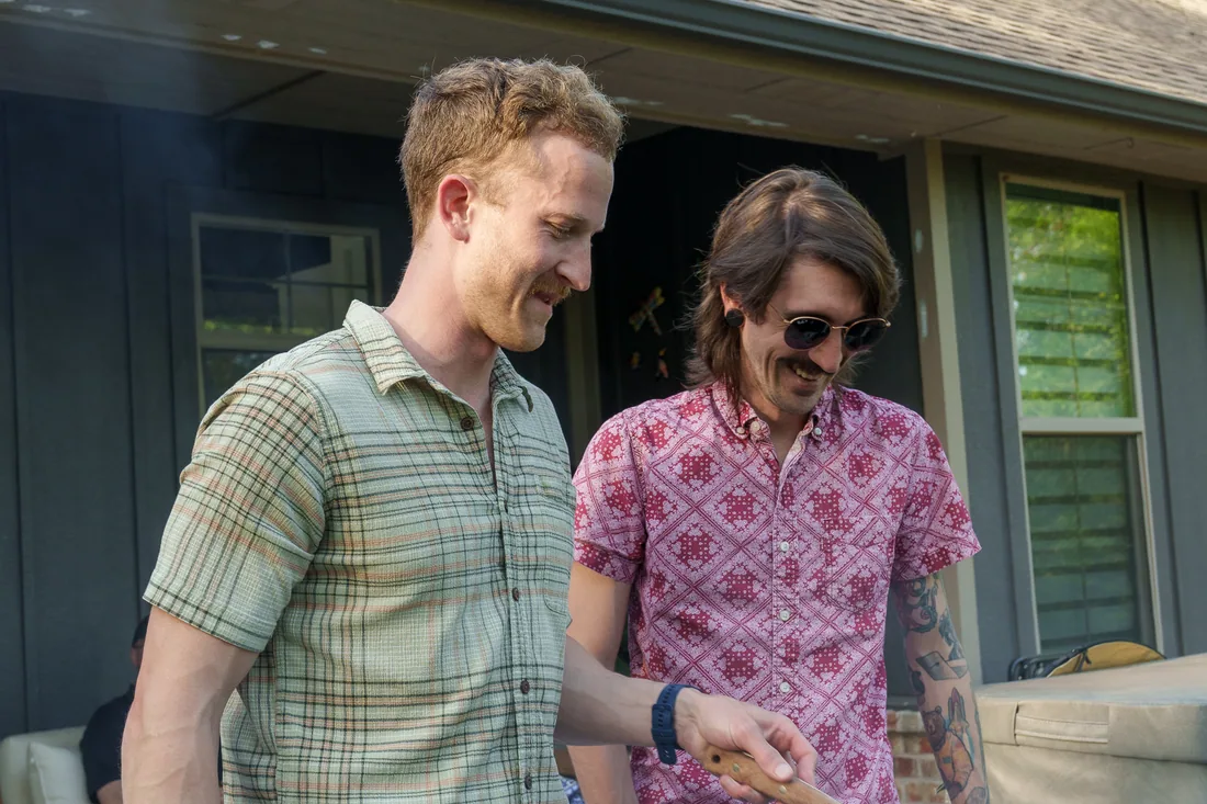 Two guests talking over the griddle at an A&K cookout
