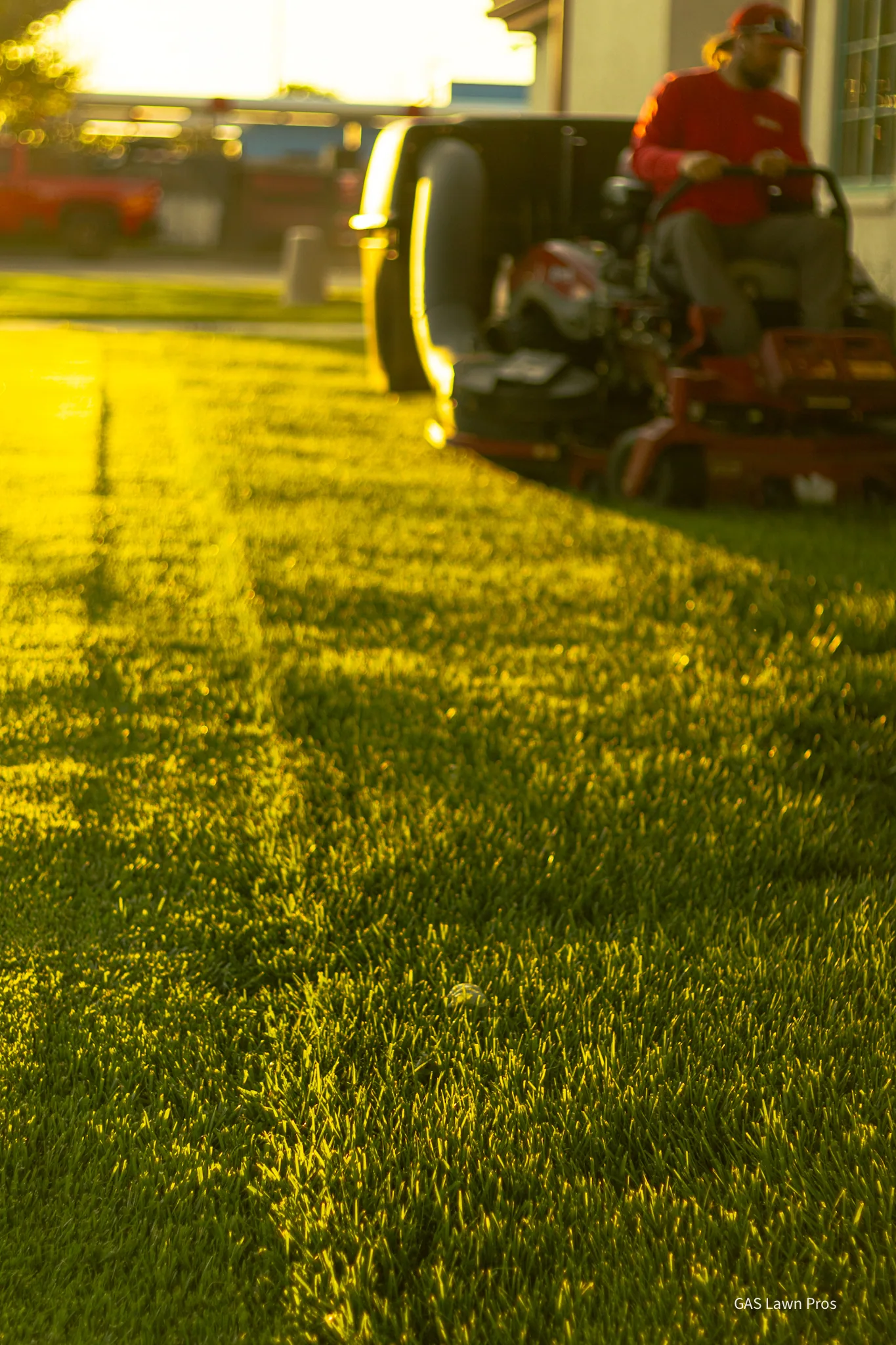 GAS Lawn Pros employee mowing at golden hour