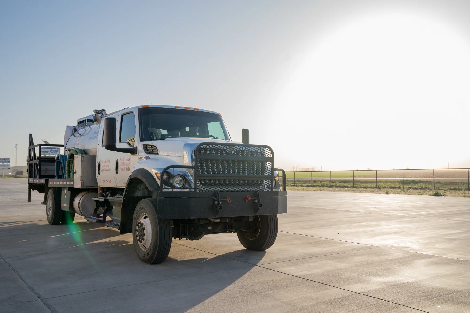 A J and J Services LLC flatbed service truck against open Western Kansas sky
