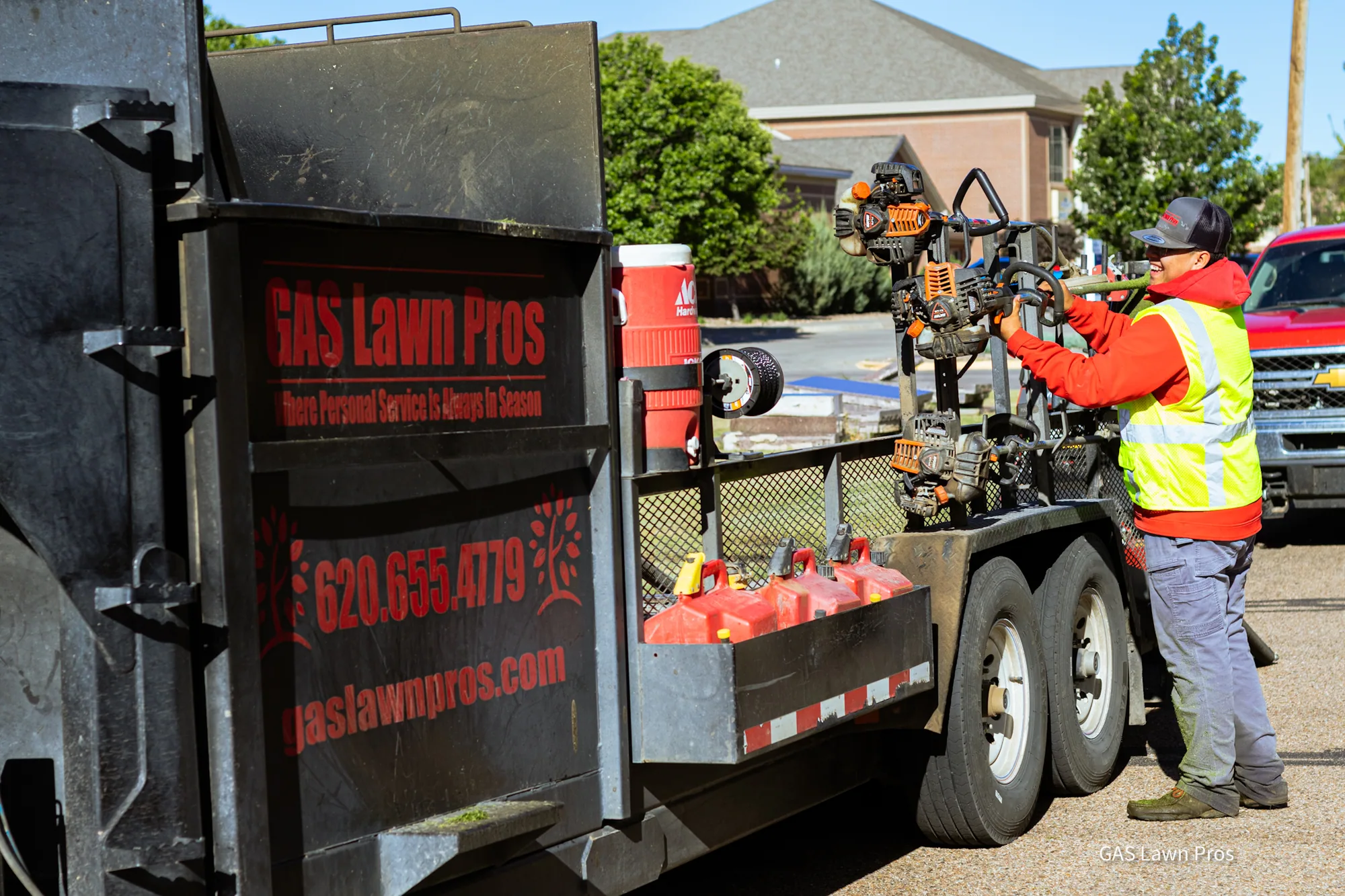 GAS Lawn Pros crew loading equipment onto the branded trailer