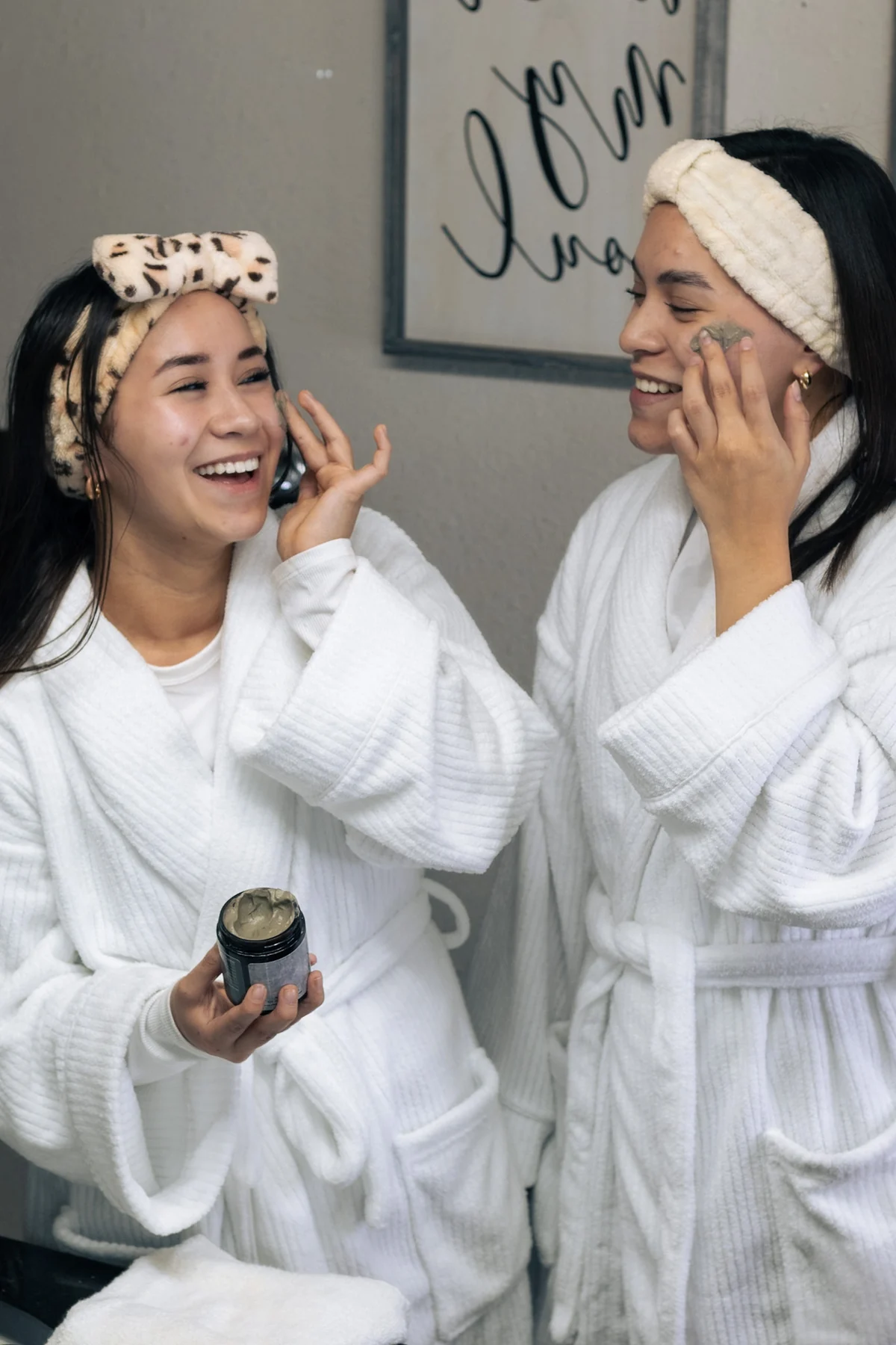 Two models in white robes and headbands holding a Reclaiming Dawn product