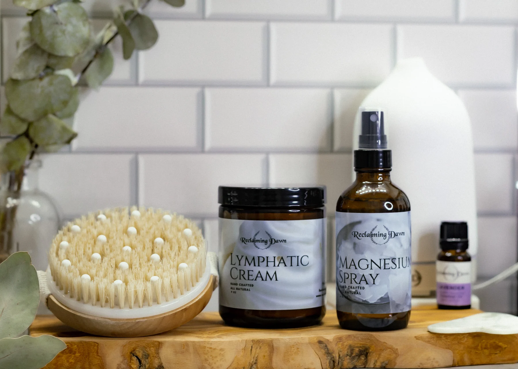 Reclaiming Dawn lymphatic cream and magnesium spray styled on a live-edge wood shelf