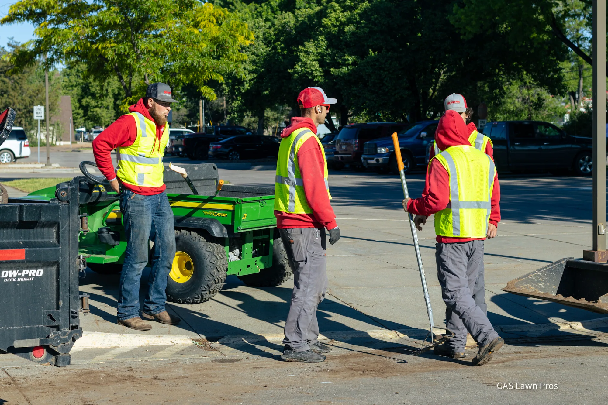 Three GAS Lawn Pros crew members with a utility vehicle on a commercial property in Liberal, Kansas