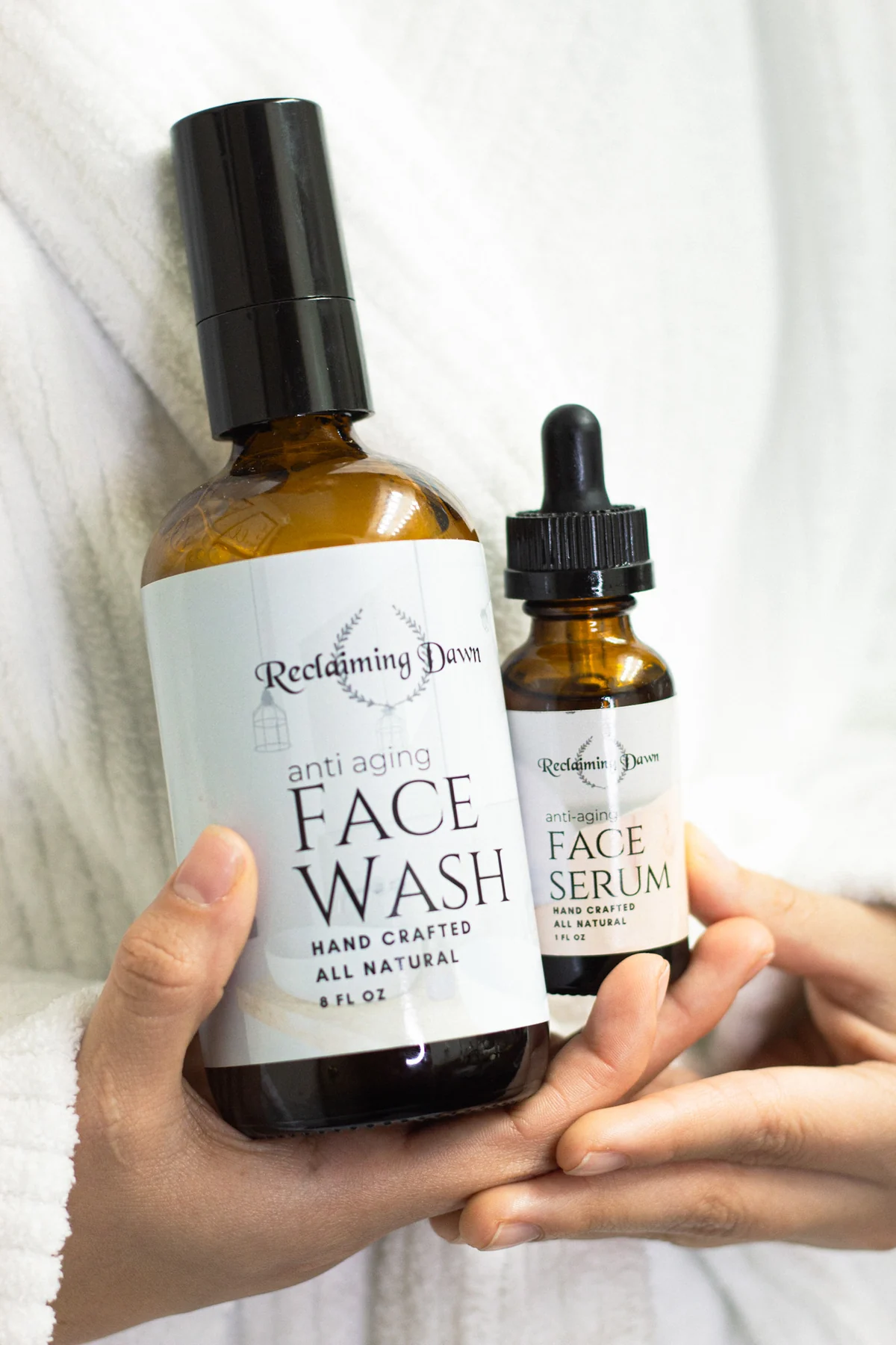 Two hands presenting Reclaiming Dawn face wash and face serum