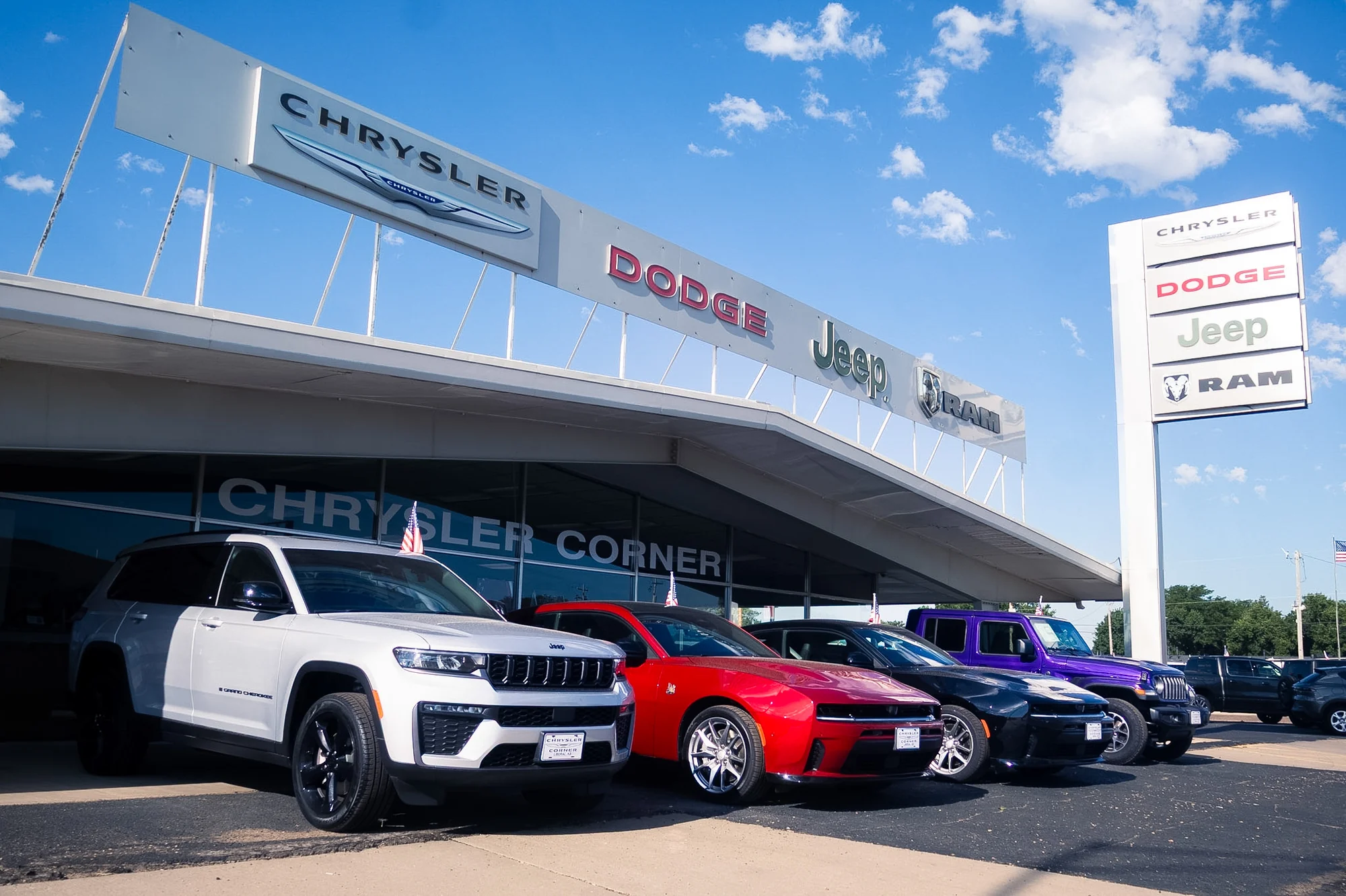 The Chrysler Corner vehicle lineup beneath the dealership pylon sign
