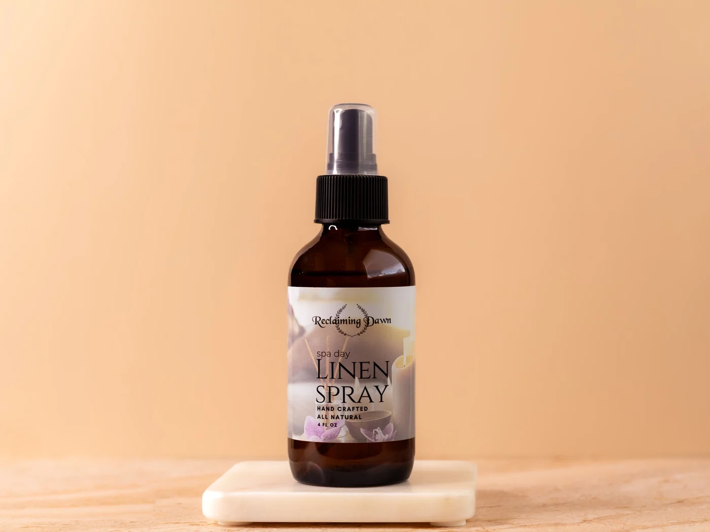 Reclaiming Dawn laundry spray bottle styled on a marble riser