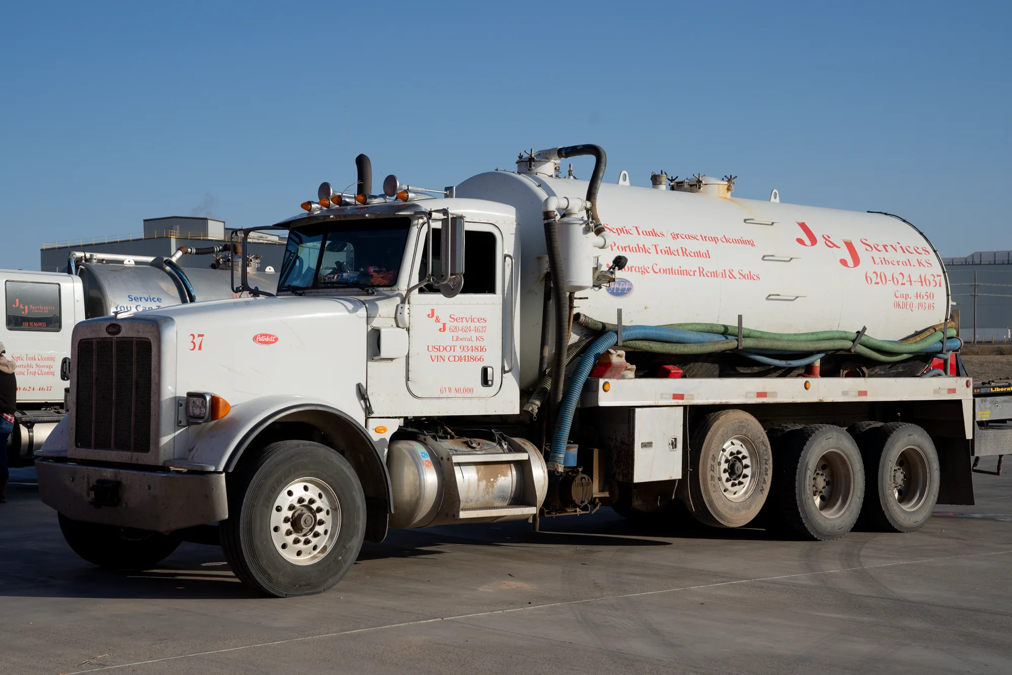 The side of a J and J Services LLC vacuum truck showing the company name and service lines