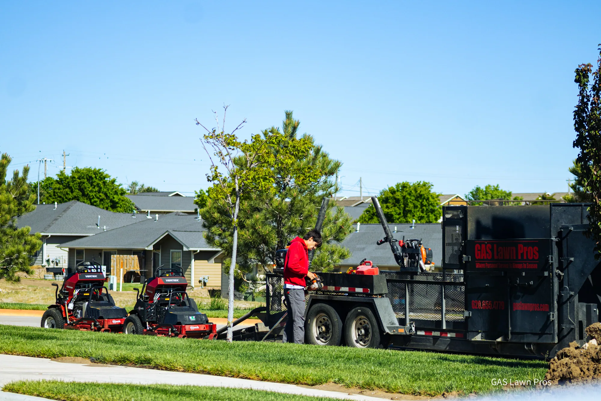 GAS Lawn Pros truck, trailer and mowers parked at a commercial property