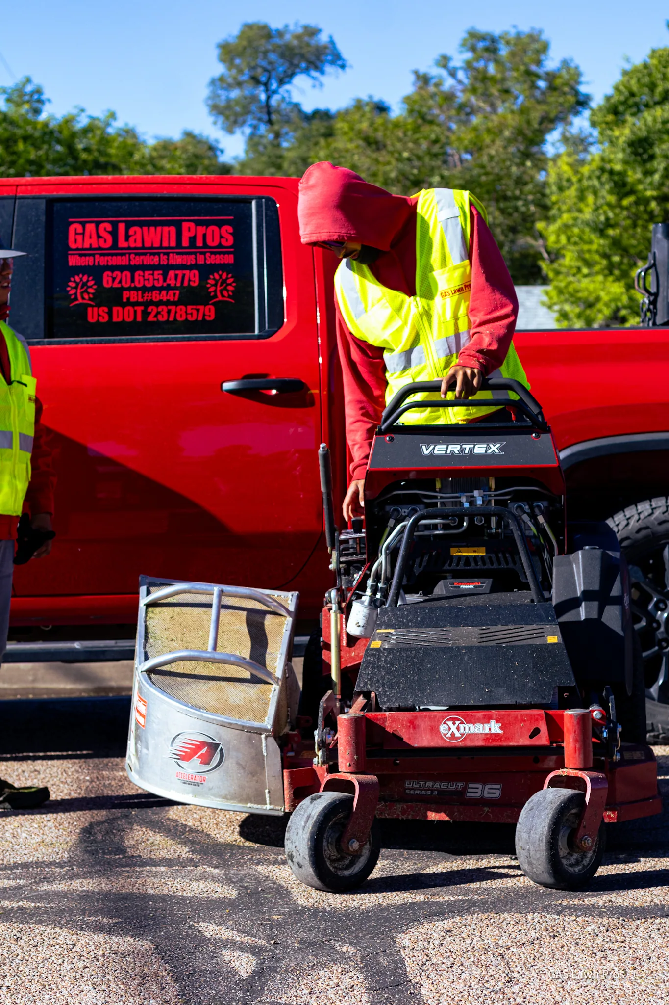 A GAS Lawn Pros employee unloading a mower from the branded truck